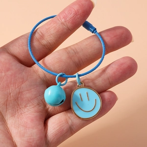 Blue wire keychain with a small bell and golden-rimmed smiley face pendant