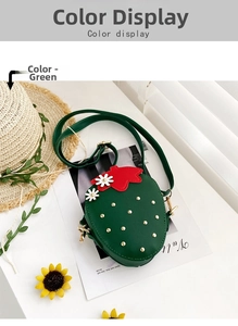 Detail of green strawberry-shaped girls' crossbody bag with gold studs and red leaves