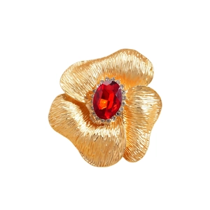 Luxury gold flower brooch with a central oval red gemstone and white diamond accents