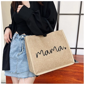Detailed close-up of a large jute tote bag featuring mama text and heart design