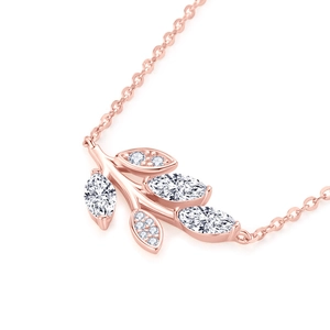 Macro shot of rose gold leaf pendant with marquise-cut white moissanite on fine chain