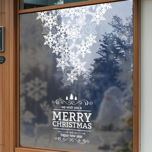 White snowflake window stickers for Christmas holiday glass decor with snowy outdoor view