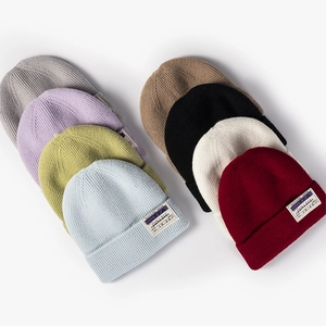 Winter thermal ribbed knit beanies in various colors with stylish woven patches