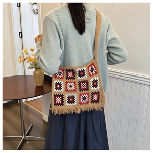 Detail of granny square crochet tote bag featuring vibrant tassels and geometric patterns