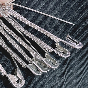 Gros plan d'épingles de sûreté en métal argenté avec strass pour ajuster la taille