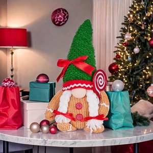 Detailed close-up of knitted Christmas gnomes with gingerbread patterns on a marble table