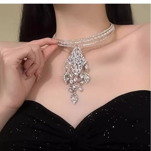 Detailed close-up of a tiered silver choker featuring sparkling rhinestones and pearls