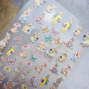 Détail d'autocollants gaufrés pour ongles lapin avec papillons et motifs de marguerites