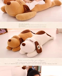 Close-up of soft plush puppy pillow with sleepy eyes and smooth brown and cream texture