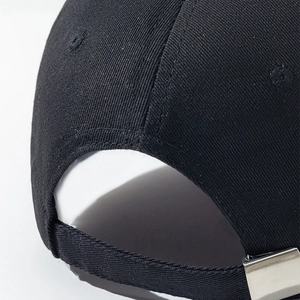 Detail of the high-density cotton fabric and silver metal buckle on the black baseball cap