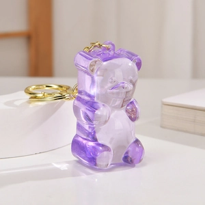 Detailed close-up of a purple translucent mini jelly bear keychain with gold ring