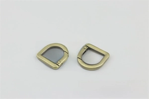 Detail of two D-ring spring screw shackles in antique bronze finish for bag hardware