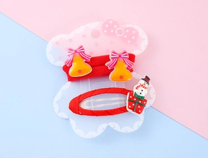 Detail of Christmas hair clips with bells and snowman on decorative display card