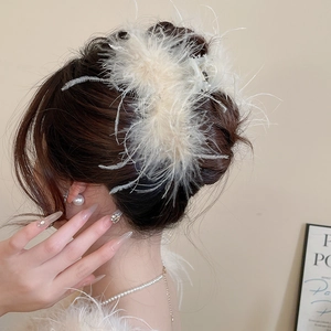 Detailed back view of a white feather hair claw clip accessorizing an elegant low bun
