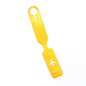 Detail of yellow faux leather luggage tag featuring embossed safety text and airplane motif