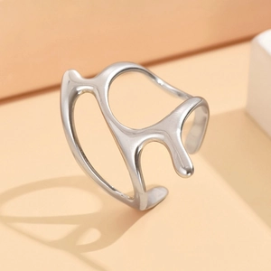 Polished silver irregular molten line stainless steel open ring on a geometric stand
