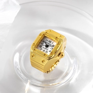 Detail of square gold ring watch with screw bezel and polished quartz movement dial