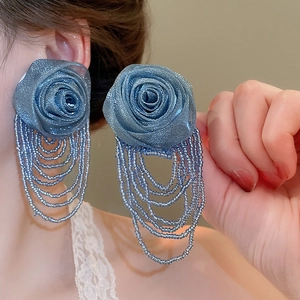 Detailed shot of large blue mesh flower earrings with dangling bead tassel fringe