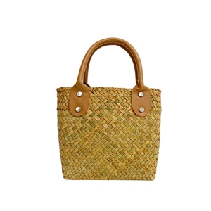 Handmade woven straw tote bag with brown PU leather handles and silver rivet accents