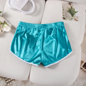 Detail of light blue satin shorts with white trim and elastic waistband on a sofa