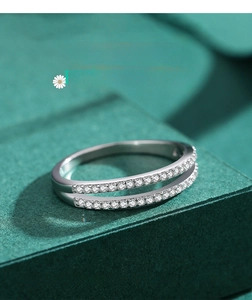 Macro shot of double-row pavé set silver rings on dark green velvet display