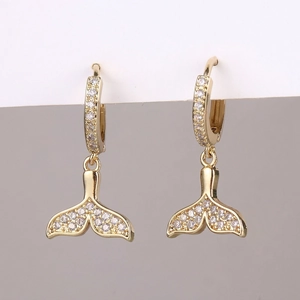 Detailed view of gold fishtail drop earrings with sparkling white cubic zirconia stones