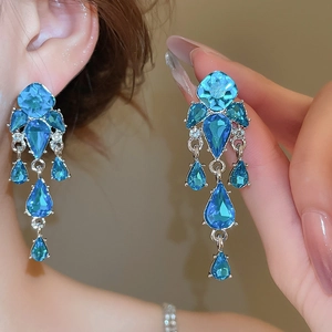Dettaglio ravvicinato di orecchini vintage con nappe di cristallo blu e base argento