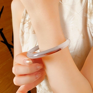 Close-up of a translucent violet round jade bangle on a wrist showing elegant texture