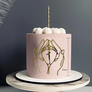 Detail of 9.5cm gold acrylic baby shower cake topper showing hands holding baby feet