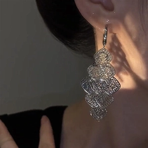 Detail of silver layered mesh tassel earrings with geometric diamond hollow design