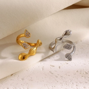 Close-up of abstract wavy open rings in gold and silver finish with zircon stones