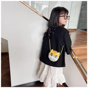 Petite fille portant le sac à bandoulière chat jaune et blanc dans l'escalier