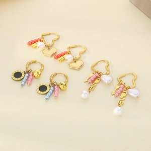 Detail of three creative heart-shaped earring sets with pearls, tassels and gold plating