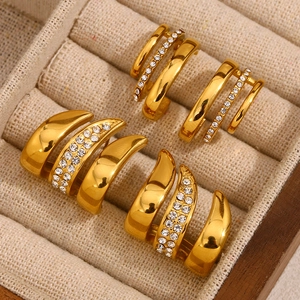 Detailed close-up of 18K gold plated flag-shaped earrings with rhinestones in a tray