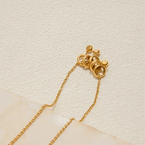 Detail of 18K gold stainless steel necklace with interlocking rings and metal beads