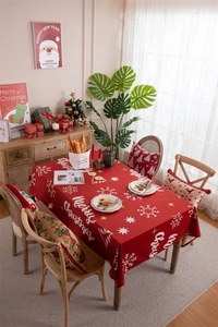 Close-up of red Christmas tablecloth with white snowflakes and Merry Christmas pattern