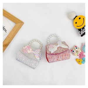 Detail of pink and white tweed kids purses with pearl handles and mermaid decorations