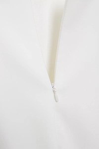 Detailed view of white dress featuring high-quality invisible zipper and stitching