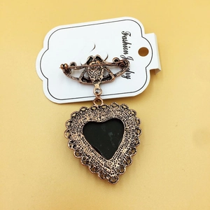 Vintage heart shaped brooch in antique gold with black inlay on display card