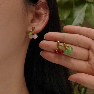 Detailed view of sweet cherry earrings with pink and red beads on gold plated titanium steel