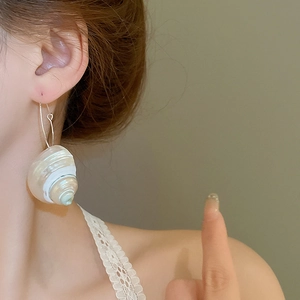 Chic conch shell hoop earrings featuring iridescent luster for beach vacation style