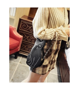 Side view of cute black cat crossbody bag with gold chain strap on a model