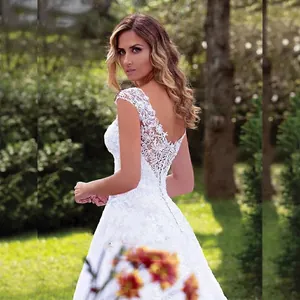 Elegant white lace wedding dress with V-back detail and floral embroidery in A-line style