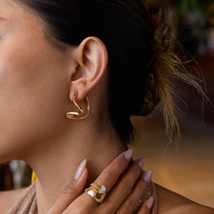 Vue détaillée de boucles d'oreilles courbes élégantes en acier inoxydable plaqué or 18 carats