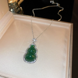Close-up of green resin gourd pendant with zircon flower detail on fine silver chain
