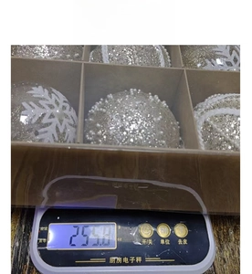 Detailed view of silver Christmas balls with snowflake patterns on a digital scale for weight