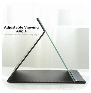 Detail showing the foldable triangular support and stitching on a leather vanity mirror