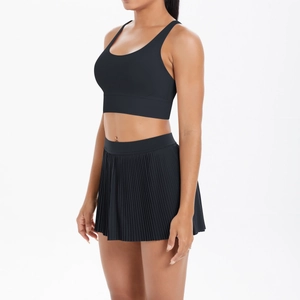 Detail of high-waist black pleated tennis skirt and matching supportive sports bra set
