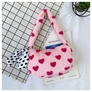 Detailed view of pink plush handbag featuring dark pink hearts and polka dot scarf detail