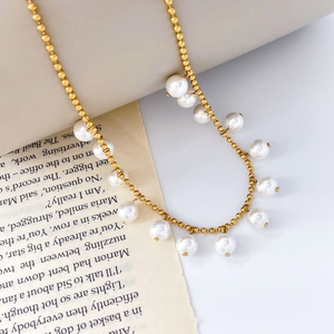Detail of gold beaded chain necklace featuring white pearls in French luxury style